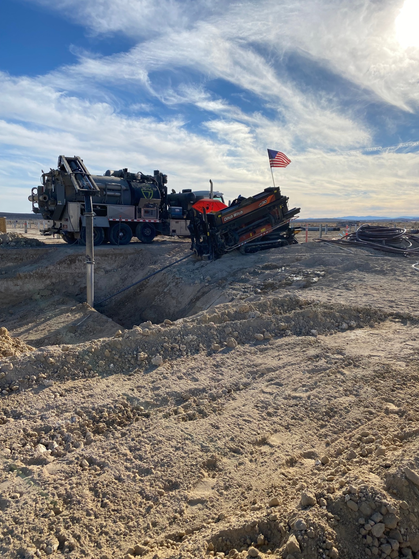 JT30 and vac truck working a deep bore pit under the American flag